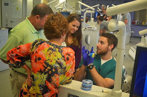  Third-year dental student Travis Moore provides a simulation lab demonstration for first-year Mary Bec Keith and her parents during the school’s 4th  Annual Family Day Celebration.  Nearly 230 attendees enjoyed interactive sessions and a tailgate lunch. 